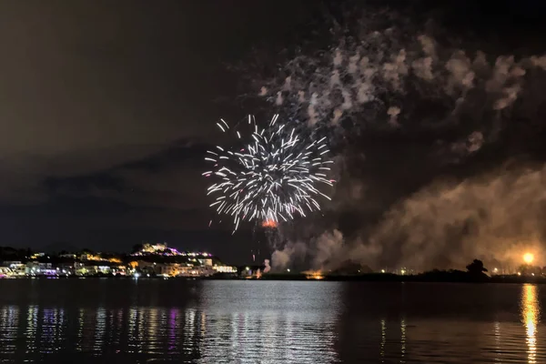 Bacoli, Napoli, 9 Ağustos 2022. Havai fişekler gökyüzünü çeşitli renklerle boyuyor ve Miseno Gölü 'ne yansıtılarak nefes kesici bir manzara yaratıyor..