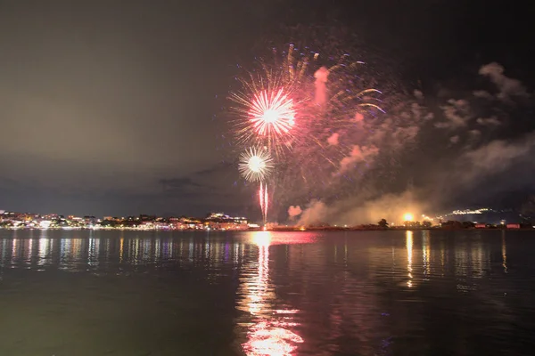 Bacoli, Napoli, 9 Ağustos 2022. Havai fişekler gökyüzünü çeşitli renklerle boyuyor ve Miseno Gölü 'ne yansıtılarak nefes kesici bir manzara yaratıyor..