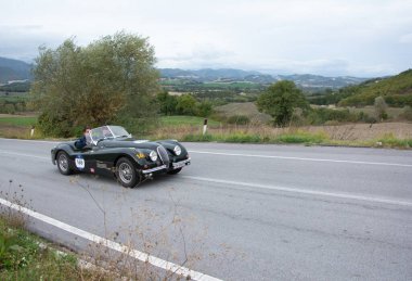 CAGLI, ITALY - OTT 24 - 2020: JAGUAR XK 120 OTS ROADSTER 1951 rallideki eski bir yarış arabası Mille Miglia 2020 ünlü İtalyan tarihi yarışı (1927-1957)