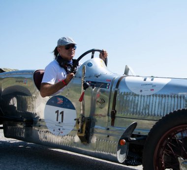 URBINO, İTALYA 16 HAZİRAN 2022: O.M. Mille Miglia 2022 rallisindeki eski bir yarış arabasında (1927-1957) ünlü İtalyan tarihi yarışı.)