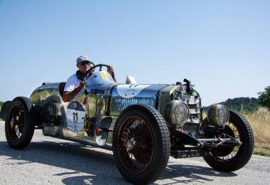 URBINO, İTALYA 16 HAZİRAN 2022: O.M. Mille Miglia 2022 rallisindeki eski bir yarış arabasında (1927-1957) ünlü İtalyan tarihi yarışı.)