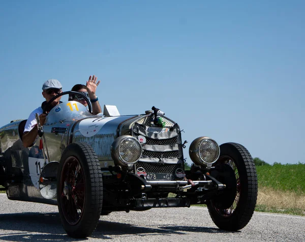 URBINO, İTALYA 16 HAZİRAN 2022: O.M. Mille Miglia 2022 rallisindeki eski bir yarış arabasında (1927-1957) ünlü İtalyan tarihi yarışı.)