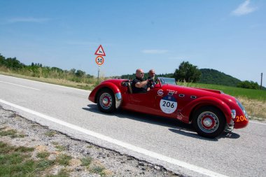 URBINO, ITALY - 16 Haziran 2022: HeALEY 2400 SILVERStONE (E-TYPE) 19501 Mille Miglia 2022 rallisinde eski bir yarış arabası üzerinde ünlü İtalyan tarihi yarışı (1927-1957)
