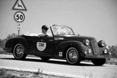 URBINO, İtalya - 16 Haziran 2022: FIAT 1100 DERBY BERTON 1944 Mille Miglia 2022 rallisinde eski bir yarış arabası üzerinde ünlü İtalyan tarihi yarışı (1927-1957)