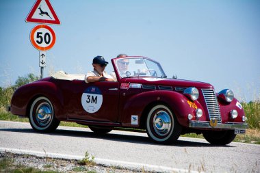 URBINO, İtalya - 16 Haziran 2022: FIAT 1100 DERBY BERTON 1944 Mille Miglia 2022 rallisinde eski bir yarış arabası üzerinde ünlü İtalyan tarihi yarışı (1927-1957)