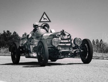 URBINO, İTALYA 16 HAZİRAN 2022: O.M. Mille Miglia 2022 rallisindeki eski bir yarış arabasında (1927-1957) ünlü İtalyan tarihi yarışı.