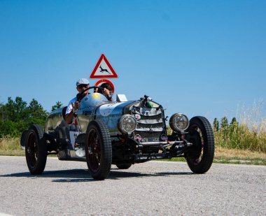 URBINO, İTALYA 16 HAZİRAN 2022: O.M. Mille Miglia 2022 rallisindeki eski bir yarış arabasında (1927-1957) ünlü İtalyan tarihi yarışı.