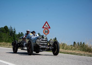 URBINO, İTALYA 16 HAZİRAN 2022: O.M. Mille Miglia 2022 rallisindeki eski bir yarış arabasında (1927-1957) ünlü İtalyan tarihi yarışı.