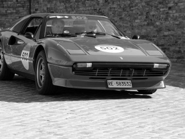URBINO, İtalya - 16 Haziran 2022 FERRARI Ferrari 308 Mille Miglia 2022 rallisinde eski bir yarış arabasına bindi
