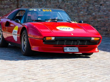 URBINO, İtalya - 16 Haziran 2022 FERRARI Ferrari 308 Mille Miglia 2022 rallisinde eski bir yarış arabasına bindi
