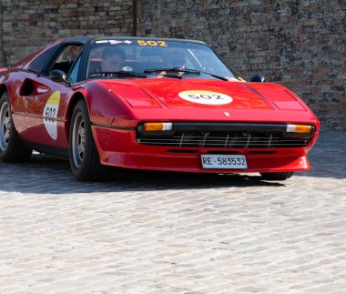 URBINO, İtalya - 16 Haziran 2022 FERRARI Ferrari 308 Mille Miglia 2022 rallisinde eski bir yarış arabasına bindi