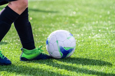 Gerçek bir amatör futbolcuya yakından bak. Futbol stadyumunun çimlerinde top oynayan bir futbolcu. Yarışma, futbol okulu, turnuva. Açık havada aksiyon sporu. Avrupa futbolu.