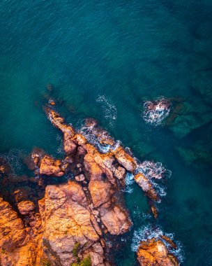 Turuncu kayalar ve mavi denizle yaz arkaplanı. Okyanus kıyısının sanatsal arka planı. Yaz kavramsal geçmişi. Costa Brava, Akdeniz, yaz tatili, plaj.