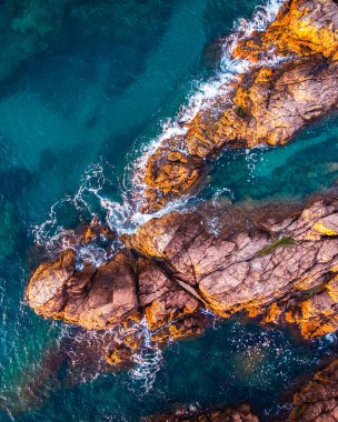Kayaların deniz manzarası ve turkuaz mavi deniz manzarası. Yaz tatillerinin kavramsal geçmişi.