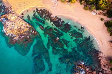 Paradisiacal plajın havadan görünüşü. Plaj turizmi geçmişi. Şeffaf turkuaz mavi suyu olan sahil..