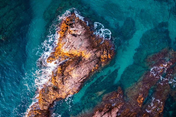 Aerial view over rocks landscape and blue turquoise sea at Costa Brava, Catalonia, Spain. Artistic summer background of the mediterranean coast. Summer conceptual background. Beach tourism vacations.