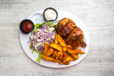 Kızarmış tavuk, patates kızartması ve salata.