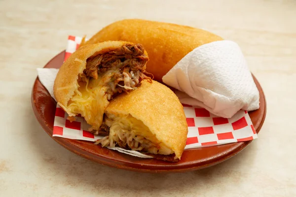 Latin American food Venezuelan empanada Peluda, shredded meat with yellow cheese