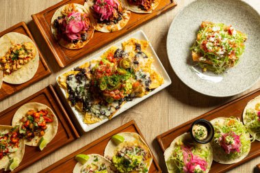 Yukarıdan görüldüğü gibi çeşitli Meksika yemekleri olan bir masa..