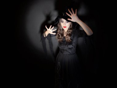 Cadılar Bayramı partisinde cadı. Klasik cadı kostümü giymiş, sivri şapkalı güzel esmer bir kadın..