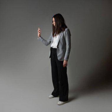 Ceket ve pantolon giymiş sıradan bir iş kadını.