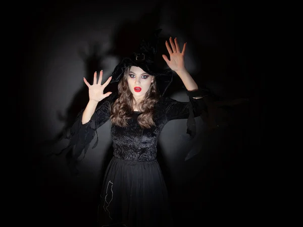 Sorcière à la fête d'Halloween, une jeune belle femme brune dans un costume de sorcière classique avec un chapeau pointu. — Photo