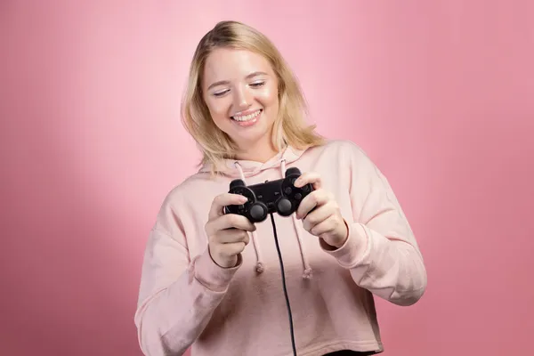Une jeune fille blonde passionnée par le jeu utilise une manette de jeu — Photo