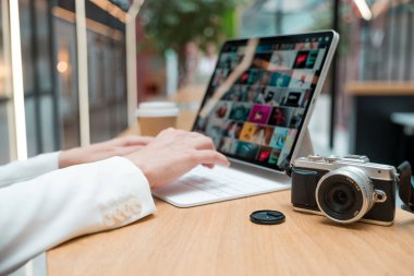 Uzaktan çalışan serbest çalışan bir fotoğrafçı, ekranda fotoğrafı olan ince bir mobil bilgisayar.