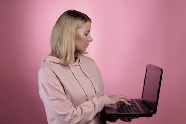 Genç bir kadın, öğrenci ya da serbest çalışan, çalışmak ya da çalışmak için dizüstü bilgisayar kullanır..