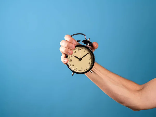Pospěš si, je čas jednat, koncepce. A man hand holds a vintage alarm clock, — Stock fotografie