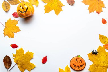 Cadılar Bayramı temalı komik bir düzen, sarı yapraklar ve yüzü olan balkabakları.,