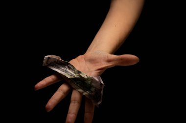 Elinde buruşmuş dolar, yoksulluk ve ekonomik kriz, konsept. Siyah anahtarlı, paralı eller.