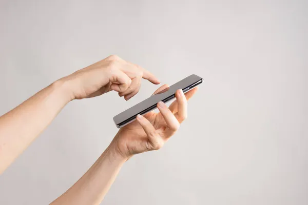 Тонкий современный смартфон в женской руке, используйте Интернет или приложения на вашем телефоне. — стоковое фото