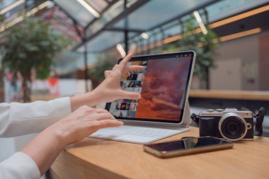 Bir fotoğrafçı ya da rötuş makinesi halka açık bir alanda dizüstü bilgisayarla ya da ortak çalışarak uzaktan çalışır..
