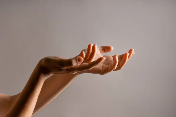 Elegante mano femenina, apuntando hacia un lado. la palma sostiene algo, un espacio en blanco para el diseño. Gestos de mano — Foto de Stock