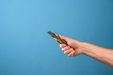 Bir şeyi kesin ya da kısaltın, kesin. Bir adamın eli kırtasiye bıçağını tutar.