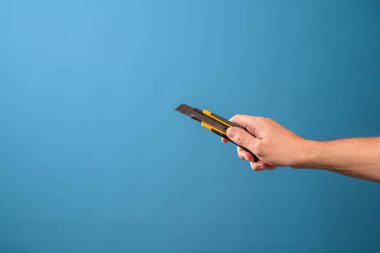 Bir şeyi kesin ya da kısaltın, kesin. Bir adamın eli kırtasiye bıçağını tutar.