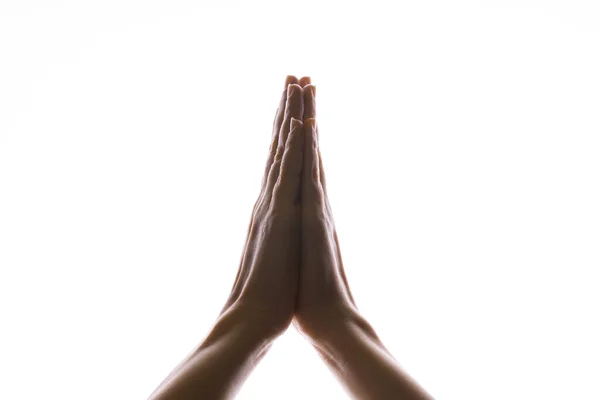 Orando con las manos sobre un fondo blanco. Luz desde arriba. Las manos dobladas en oración. Gestos de mano — Foto de Stock