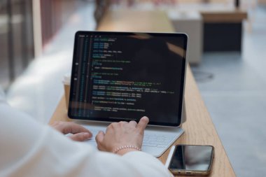 Serbest çalışan bir programcı uzaktan çalışır, genç bir kadın iş ya da iş merkezindeki bir masada oturur.