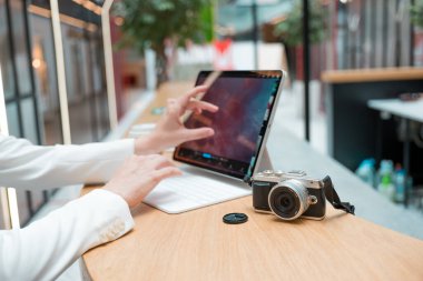 Uzaktan çalışan serbest çalışan bir fotoğrafçı, ekranda fotoğrafı olan ince bir mobil bilgisayar.