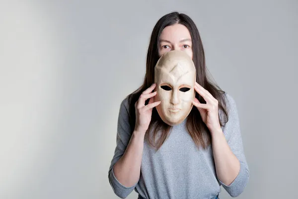 Młoda kobieta ukrywa twarz za maską, koncepcja problemów psychologicznych, — Zdjęcie stockowe