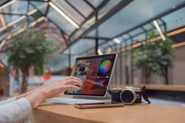 Uzaktan çalışan serbest çalışan bir fotoğrafçı, ekranda fotoğrafı olan ince bir mobil bilgisayar.