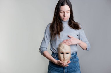 Genç bir kadın midesinde bir maske tutuyor..