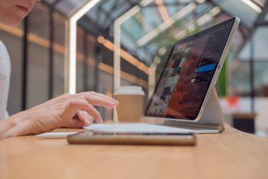 Bir fotoğrafçı ya da rötuş makinesi halka açık bir alanda dizüstü bilgisayarla ya da ortak çalışarak uzaktan çalışır..