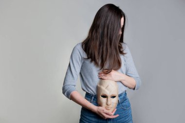 Genç bir kadın midesinde bir maske tutuyor..