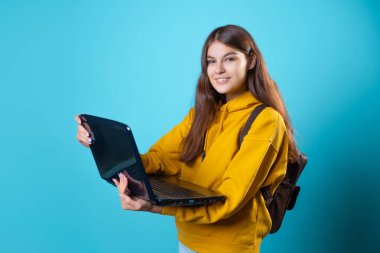 Uzaktan çalışma, yeni bir normal, bir konsept. Elinde dizüstü bilgisayar olan bir öğrenci.,