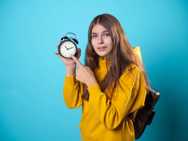 Dépêche-toi, concept. Une jeune brune dans un sweat à capuche de jeunesse tient un réveil — Photo