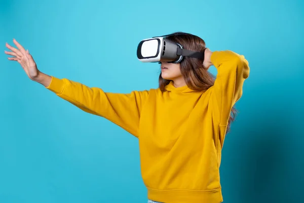 VR gamer, o femeie tânără într-un costum de tineret folosește o cască de realitate virtuală. Imagine de stoc