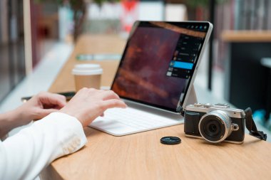 Uzaktan çalışan serbest çalışan bir fotoğrafçı, ekranda fotoğrafı olan ince bir mobil bilgisayar.