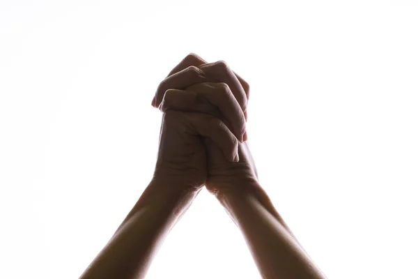 Praying crossed hands on a white background. Light from above. Hands folded in prayer. — Stock Photo, Image